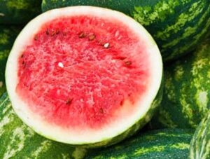 Pile of melons in stall with one cut for viewing